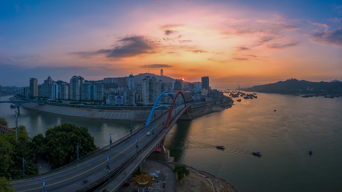 3、2022年8月2日，广西梧州市鸳鸯江上迎来了美丽的朝霞，与城市建筑、江河、过往船只交相辉映，如一幅夏日油画，美不胜收。（何华文）