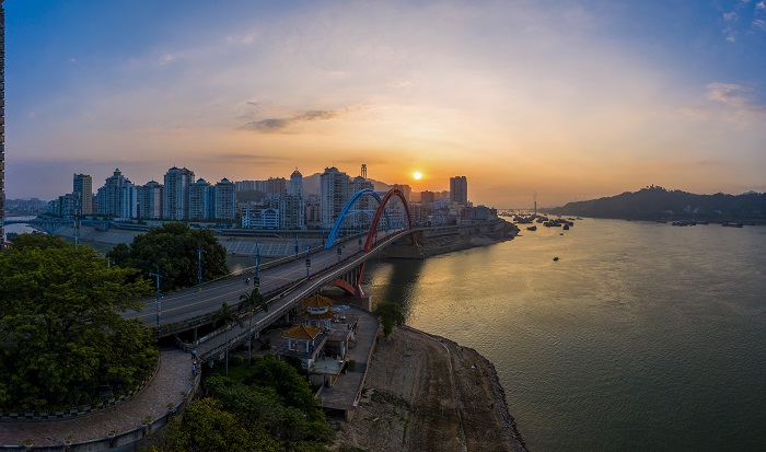 4、2022年8月2日，广西梧州市鸳鸯江上迎来了美丽的朝霞，与城市建筑、江河、过往船只交相辉映，如一幅夏日油画，美不胜收。（何华文）
