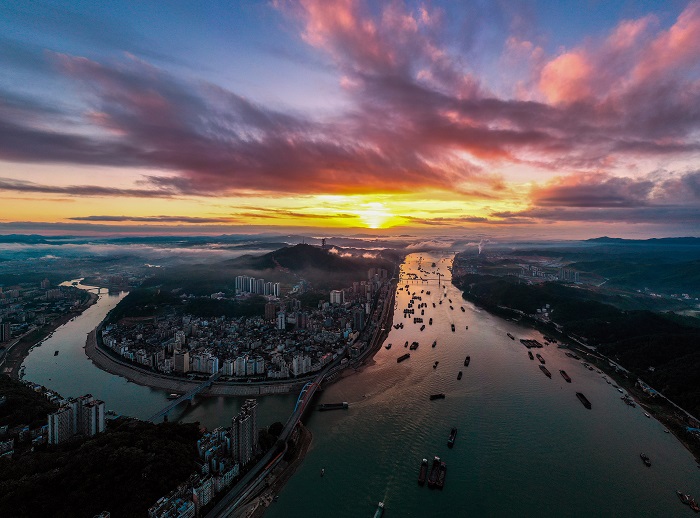 11、2022年8月9日，广西梧州市城市、西江上过往船只在朝霞的映照下美不胜收。（何华文）
