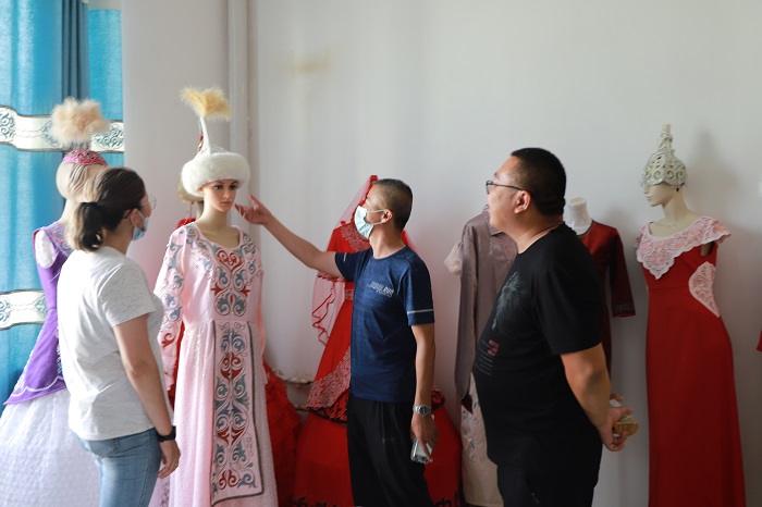 顾客正在阿勒泰地区富蕴县阿克依额克民族刺绣专业合作社参观刺绣产品。