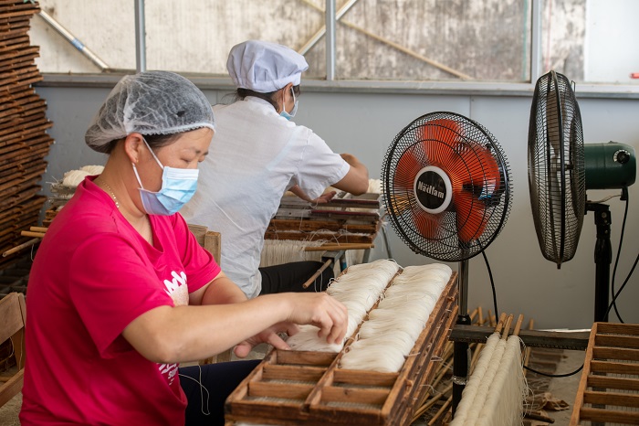 11、2022年9月22日，广西梧州市苍梧县京南米粉厂，工人在米粉出丝生产线上忙碌。（何华文）