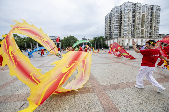 4、2022年9月30日，“彩带龙”爱好者在广西梧州市龙圩区世纪广场舞“彩带龙”，强身健体。（何华文）