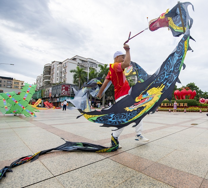 18、2022年9月30日，“彩带龙”爱好者在广西梧州市龙圩区世纪广场舞“彩带龙”，强身健体。（何华文）