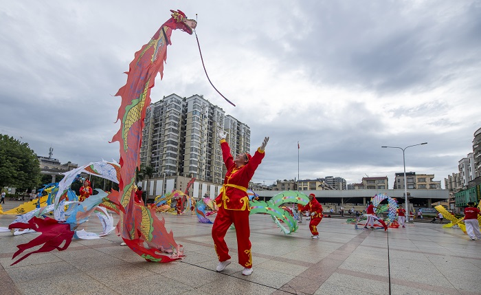 20、2022年9月30日，“彩带龙”爱好者在广西梧州市龙圩区世纪广场舞“彩带龙”，强身健体。（何华文）