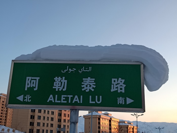 这是2022年12月3日在新疆阿勒泰地区阿勒泰市拍摄的戴着“雪帽子”的 路牌。