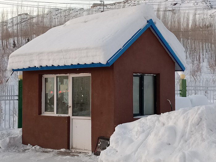 这是2022年12月3日在新疆阿勒泰地区阿勒泰市拍摄的戴着“雪帽子”的 门房。