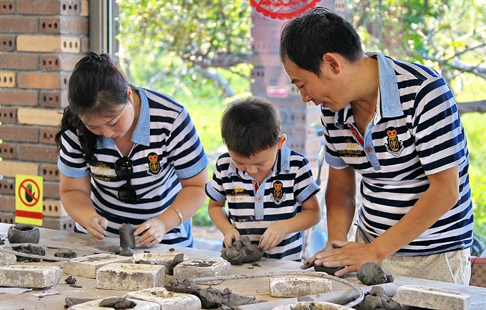 游客们在陶艺体验馆玩泥制陶