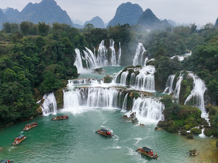 3、2023年1月23日，游客在广西崇左市大新县德天跨国大瀑布乘坐竹筏观赏气势磅礴的瀑布。（何华文）