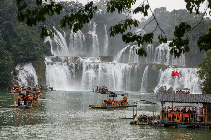 9、2023年1月23日，游客在广西崇左市大新县德天跨国大瀑布乘坐竹筏观赏气势磅礴的瀑布。（何华文）