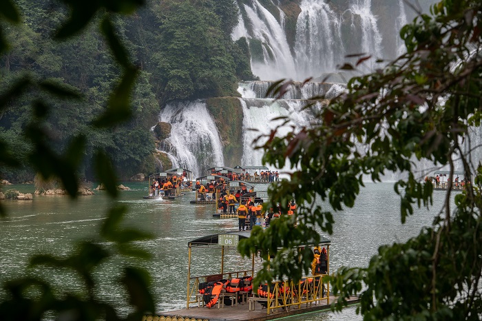 14、2023年1月23日，游客在广西崇左市大新县德天跨国大瀑布乘坐竹筏观赏气势磅礴的瀑布。（何华文）