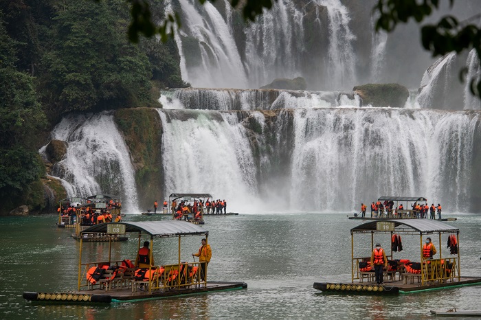 20、2023年1月23日，游客在广西崇左市大新县德天跨国大瀑布乘坐竹筏观赏气势磅礴的瀑布。（何华文）