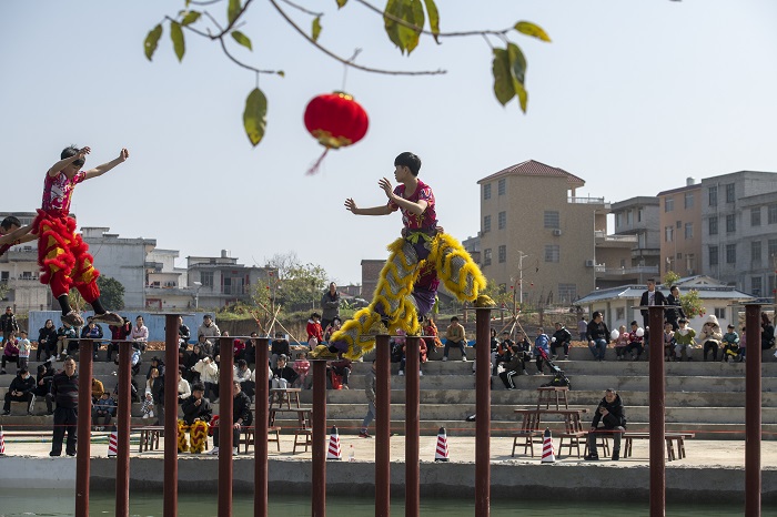 3、2023年1月25日，广西梧州市藤县濛江镇泗洲村，民间舞狮艺人在水上高桩舞狮表演闹新春。（何华文）