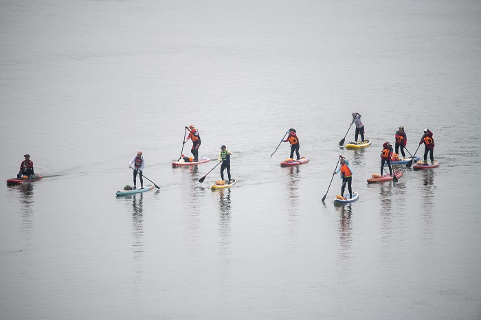 7、2023年1月27日，广西梧州市西江河面上，桨板爱好者在练习桨板，锻炼身体，体验水上运动，乐享假期。（何华文）