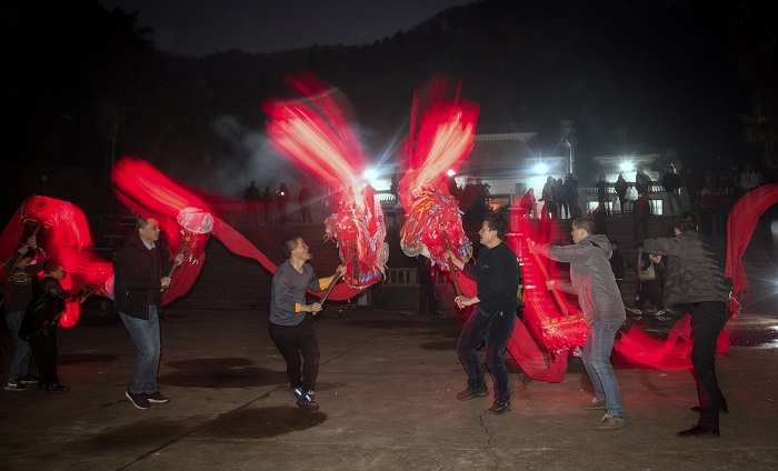 蓝氏新宗祠前，两条喜庆的红龙在烟花灿烂的夜空下欢快起舞。