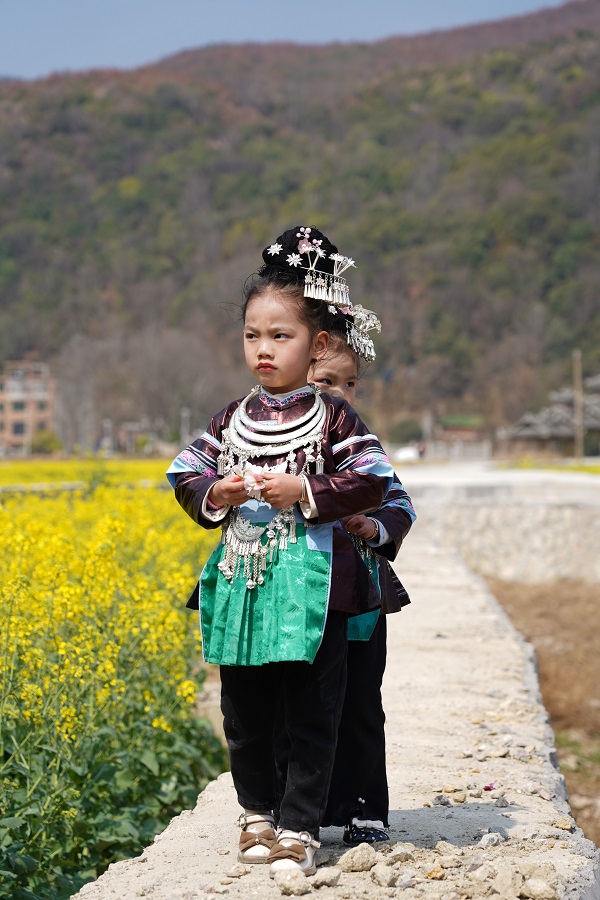 2023年2月26日，在贵州省黔东南苗族侗族自治州从江县洛香镇上皮林村，两位小朋友正走在田间赏花。