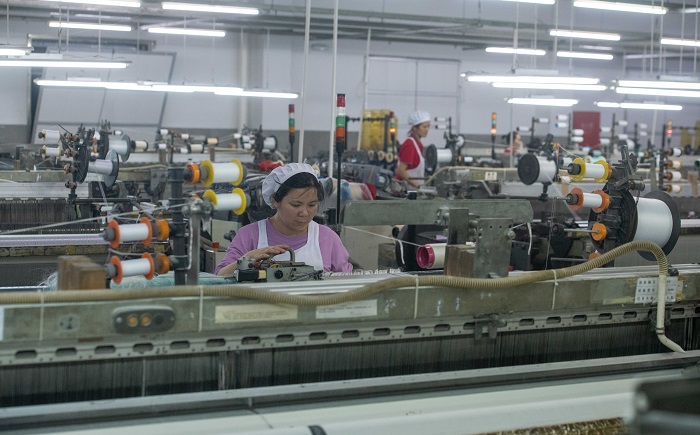 1、2023年3月15日，广西梧州市蒙山县一家纺织企业生产车间内，工人们在生产线上忙碌，生产车间一片繁忙。（何华文）