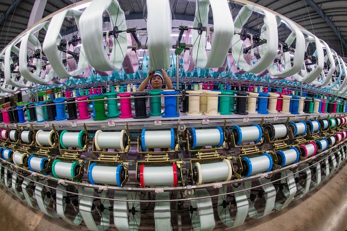2、2023年3月15日，广西梧州市蒙山县一家纺织企业生产车间内，工人们在生产线上忙碌，生产车间一片繁忙。（何华文）