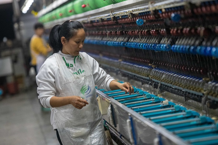 14、2023年3月15日，广西梧州市蒙山县一家纺织企业生产车间内，工人们在生产线上忙碌，生产车间一片繁忙。（何华文）
