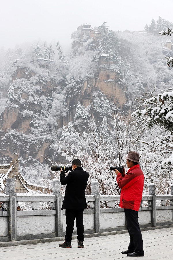 10——4月4日，摄影爱好者在甘肃省平凉市崆峒山上拍摄雪景。