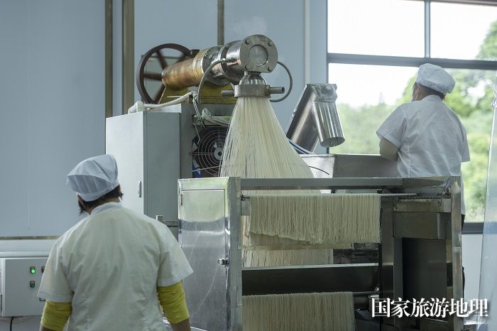 3、2023年4月24日，在广西梧州市苍梧县村级集体经济产业示范园广西京南米粉食品科技有限公司车间内，村民在用机器加工米粉。（何华文）
