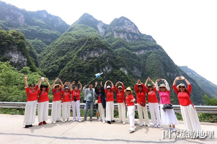 图3：520游客与下庄天路和奇峰异岭留壮观之影。2023年5月20日，摄于重庆巫山下庄天路。唐金生摄