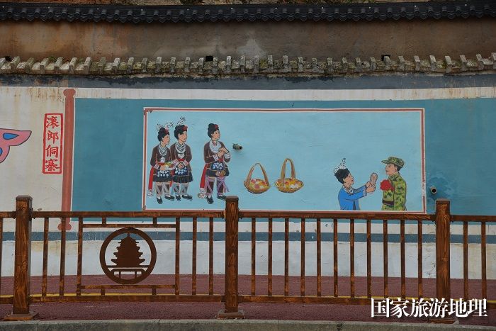 图为：在从江县月亮湾墙体绘画民族特色文化（陈灵 摄）