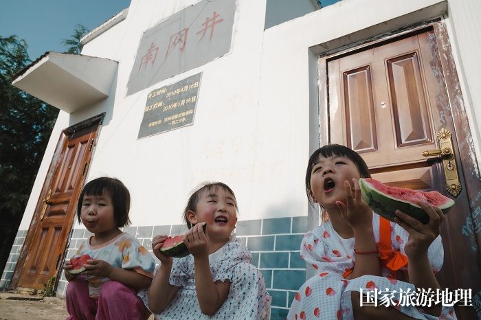 5月30日，六枝特区郎岱镇青菜塘村，小朋友们在南网井前吃西瓜。 (2)