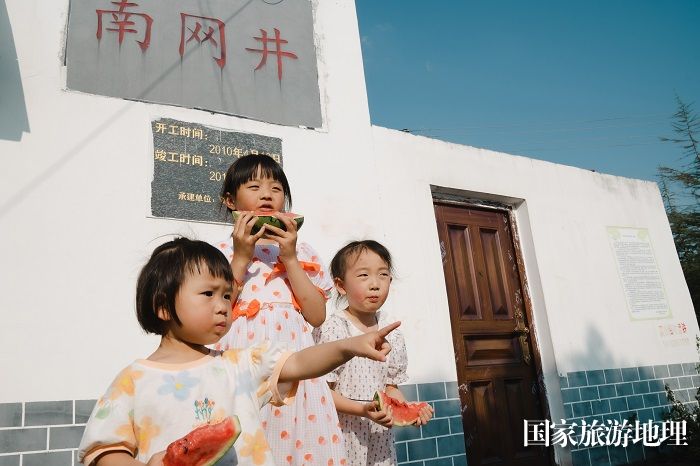 5月30日，六枝特区郎岱镇青菜塘村，小朋友们在南网井前吃西瓜。