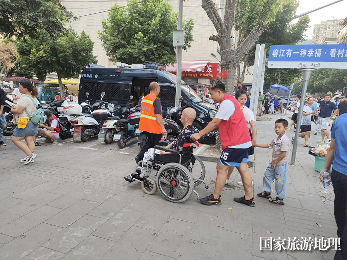 志愿者帮助行动不便球迷到现场观赛