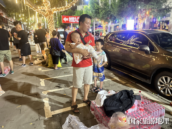 志愿者帮助游客照看小孩