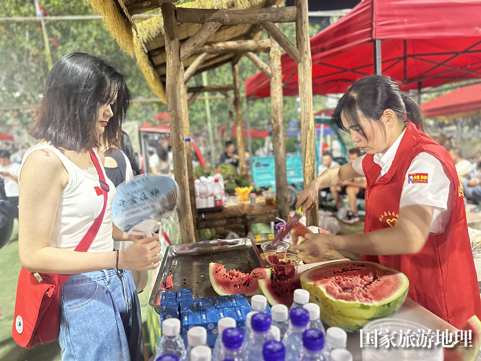 志愿者为游客切免费水果