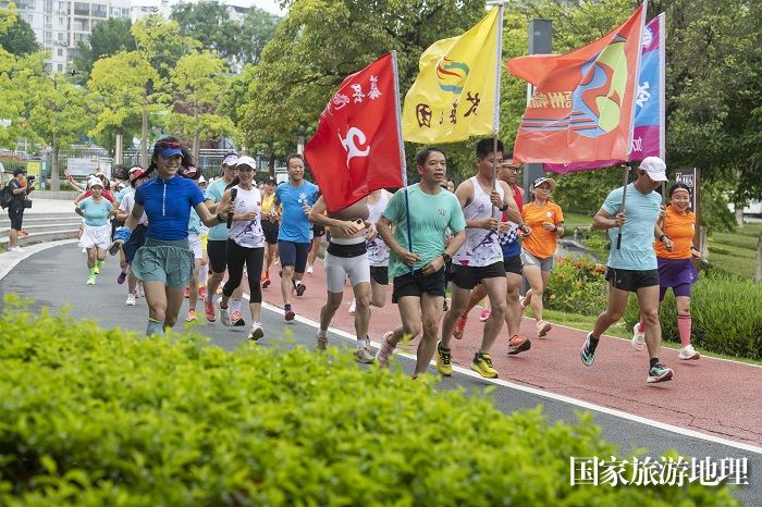 4、2023年7月16日，广西梧州市80多名跑步爱好者来到该市玫瑰湖公园健身步道进行跑步健身。（何华文）