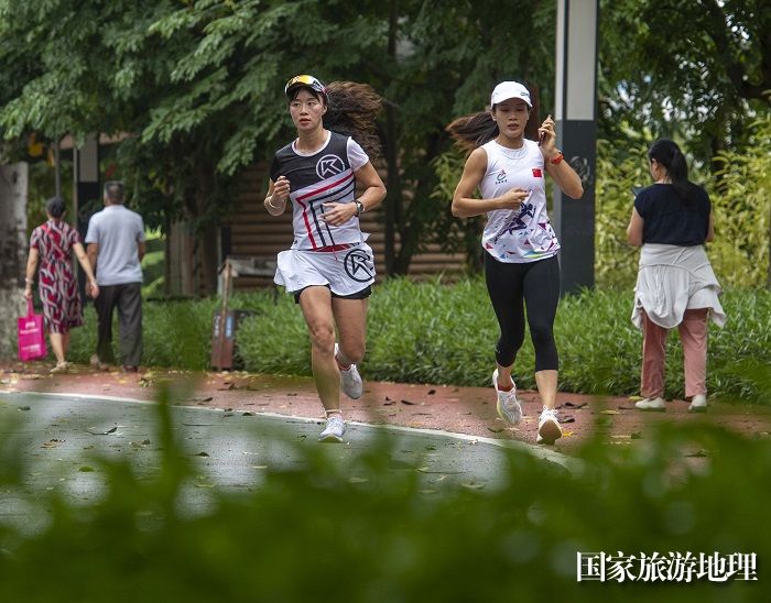 12、2023年7月16日，广西梧州市80多名跑步爱好者来到该市玫瑰湖公园健身步道进行跑步健身。（何华文）