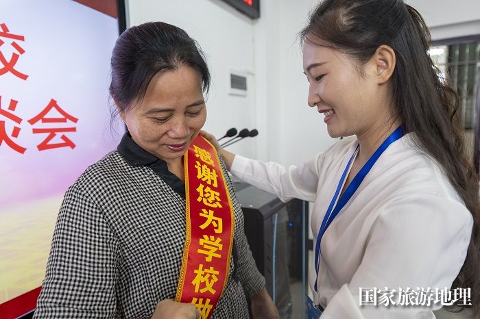 13、2023年9月8日，在广西梧州商贸学校，学生为退休前辈佩戴荣誉绶带，表达感恩之情。（何华文）