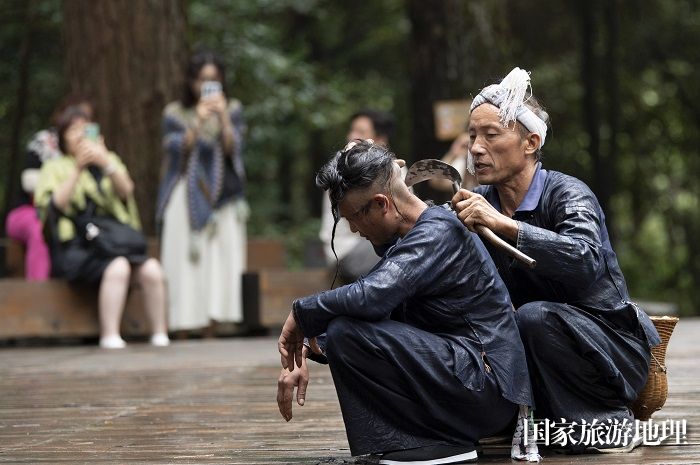 2023年9月13日，贵州省从江县丙妹镇岜沙苗寨的村民在为游客展示镰刀剃头。_DSC6303_1