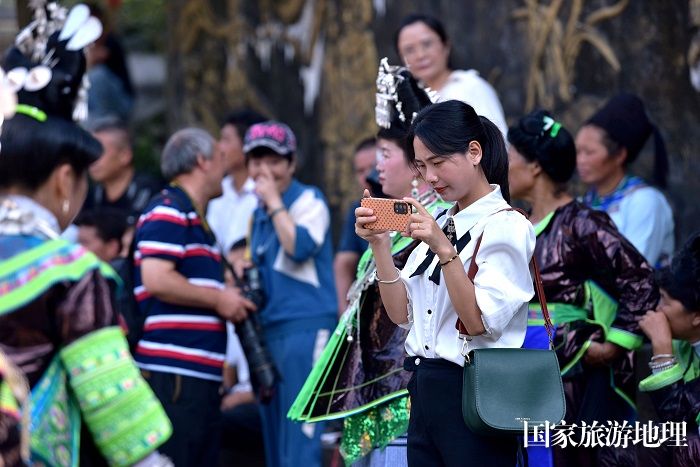 2023年9月23日，游客在贵州省荔波县佳荣镇大土村拍摄芦笙舞。