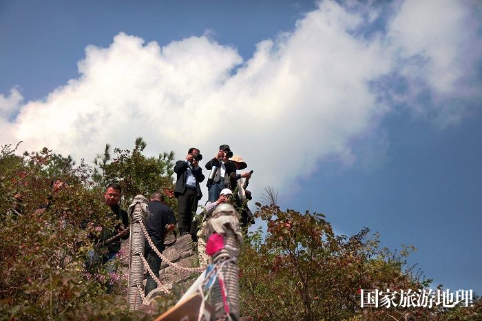 图9：巫山摄协会员正在红叶丛中拍摄巫峡云天。唐金生摄