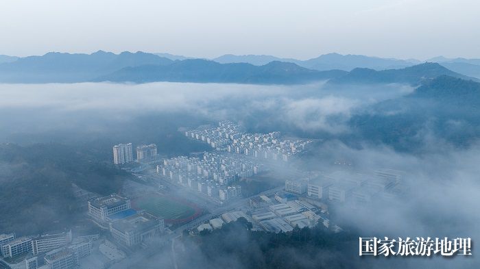 1、2023年11月23日，俯瞰广西河池市凤山县城一幢幢排列整齐的老乡家园、喀斯特青山在云雾缭绕下，宛如一幅生态画卷，美不胜收。（何华文）