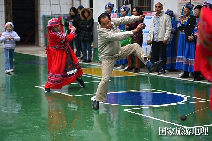 图11：12月2日，在广西河池市大化瑶族自治县仁良村，村民们和游客在比赛打陀螺。（谭凯兴 摄）