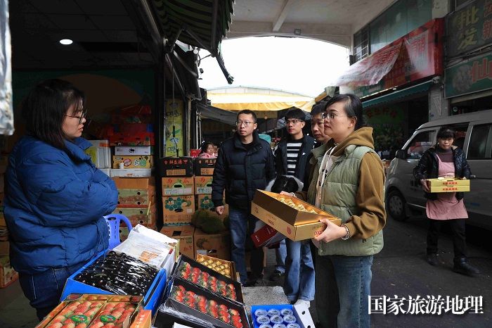 图3：12月17日，在福建省厦门中埔水果批发市场，融安县推介人员了解金桔销售行情。（谭凯兴 摄）
