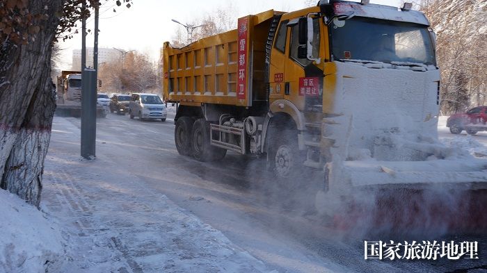 正在阿勒泰市一主街道清理积雪的大型机械设备。