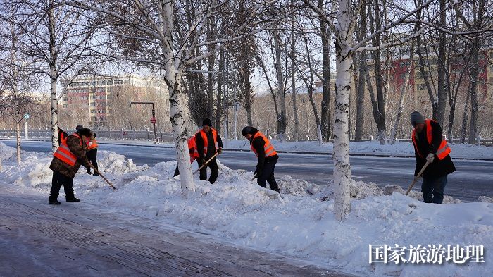 正在阿勒泰市主街道清理积雪的环卫工人。 (1)
