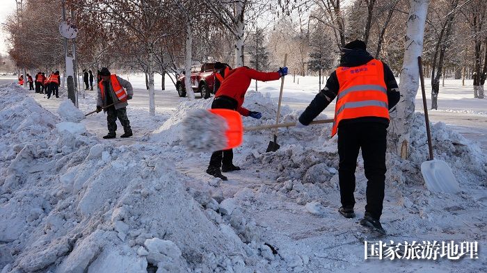 正在阿勒泰市主街道清理积雪的环卫工人。 (2)