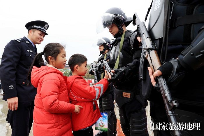 图5：1月7日，在广西柳州市融安县长安广场，小朋友在触摸警用枪械。（谭凯兴 摄）