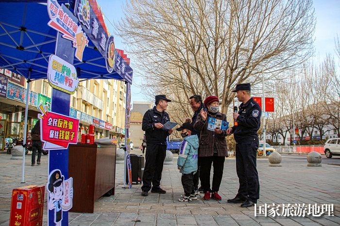 民警正在向群众宣讲相关电信防骗知识。