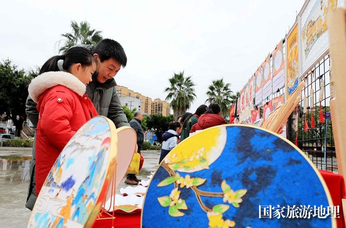 图2：1月20日，在广西柳州市融安县长安广场，市民在非遗集市上欣赏作品。（谭凯兴 摄）