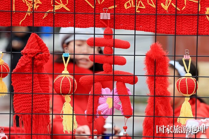 图4：1月20日，在广西柳州市融安县长安广场，市民在非遗集市上欣赏作品。（谭凯兴 摄）