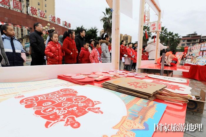 图12：1月20日，市民和学生在广西柳州市融安县长安广场非遗小集市上选购作品。（谭凯兴 摄）