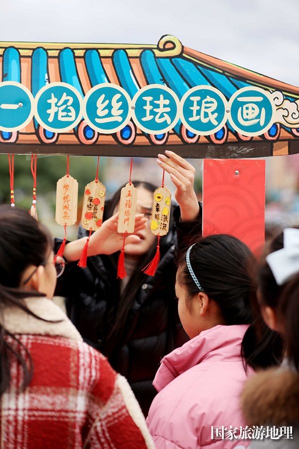 图13：1月20日，在广西柳州市融安县长安广场，市民在选购非遗作品。（谭凯兴 摄）