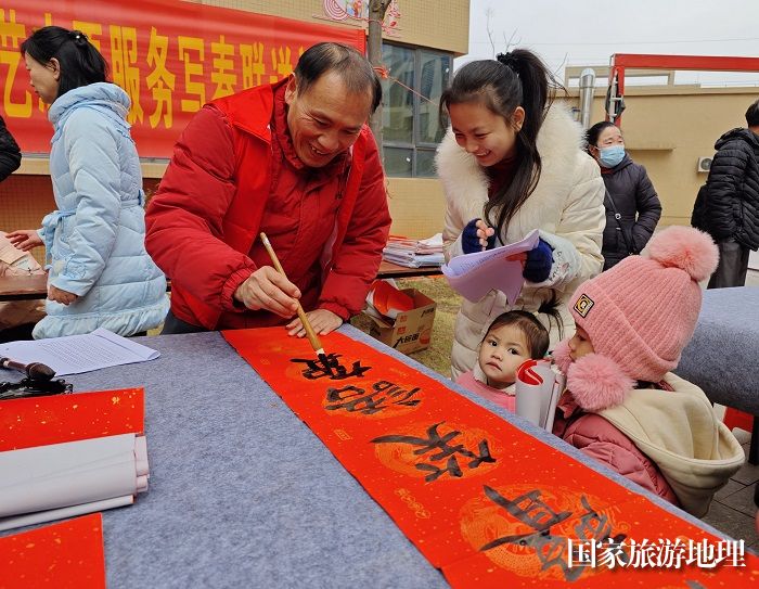 平桂区书法协会会员在为群众义写春联。
